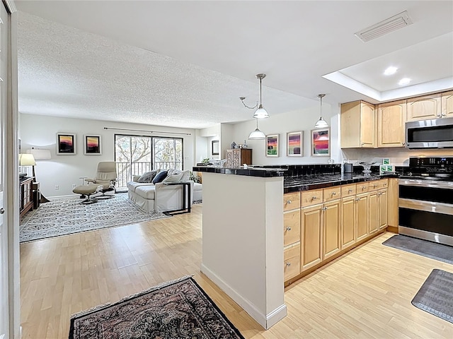 kitchen with visible vents, light brown cabinets, open floor plan, light wood-style floors, and appliances with stainless steel finishes