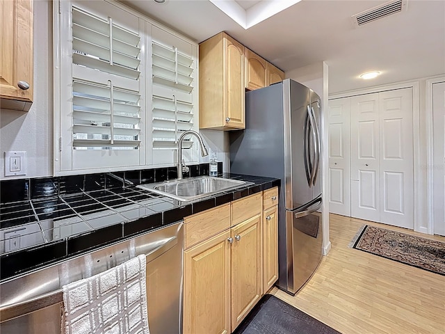 kitchen with tile countertops, visible vents, light brown cabinetry, and a sink