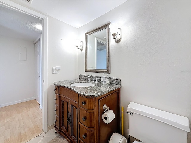 bathroom with vanity, toilet, and baseboards