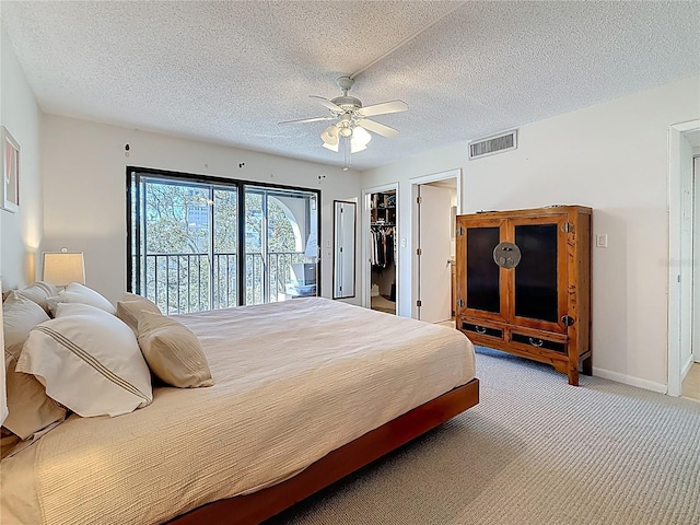 bedroom featuring access to exterior, visible vents, carpet flooring, and a textured ceiling