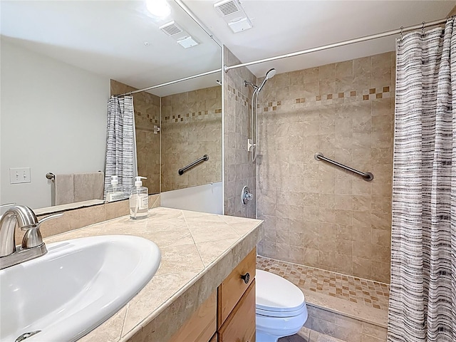 full bath featuring visible vents, toilet, tiled shower, and vanity