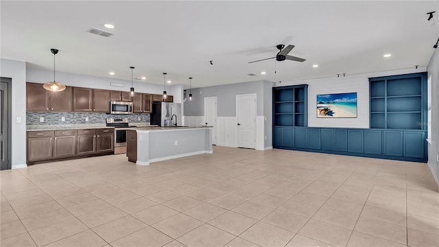 kitchen featuring ceiling fan, light countertops, appliances with stainless steel finishes, decorative light fixtures, and open floor plan