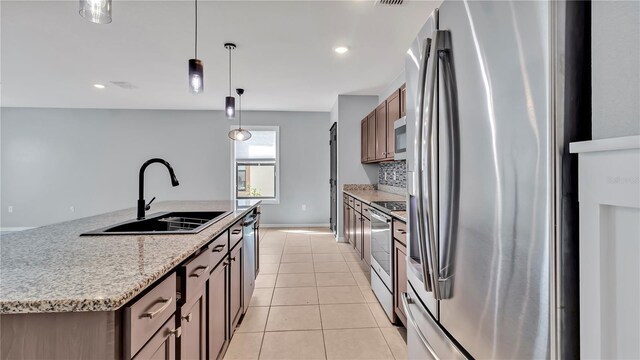 kitchen featuring light tile patterned floors, recessed lighting, a sink, appliances with stainless steel finishes, and pendant lighting