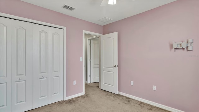 unfurnished bedroom with visible vents, ceiling fan, baseboards, light carpet, and a closet