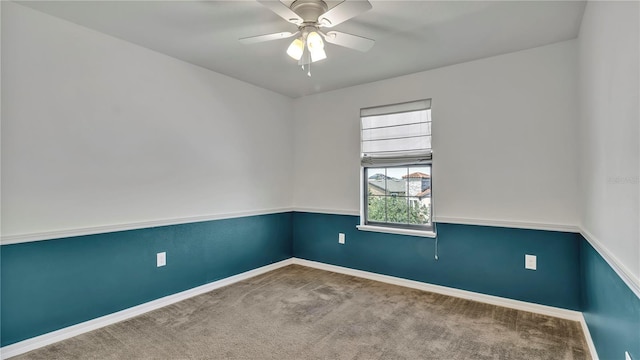 carpeted empty room with a ceiling fan and baseboards