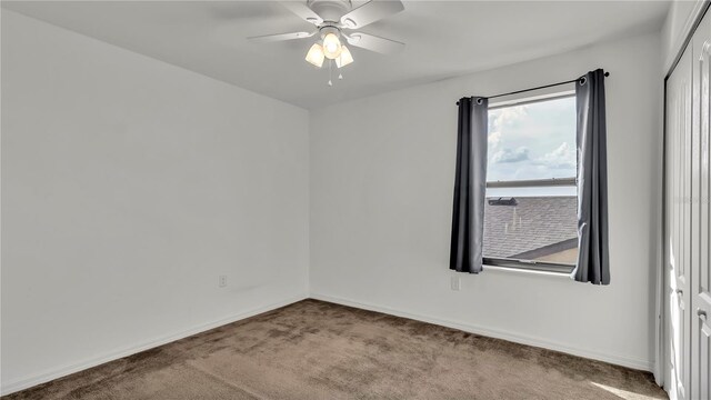 spare room featuring baseboards, carpet, and a ceiling fan