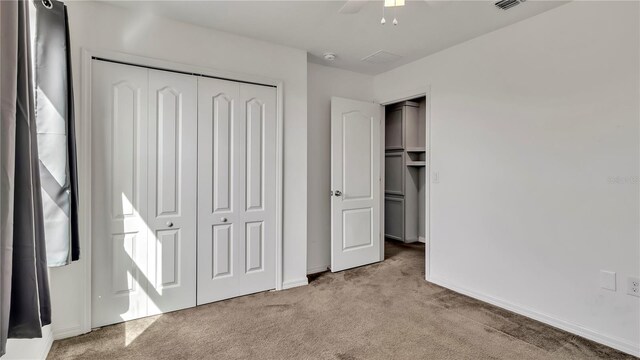 unfurnished bedroom featuring visible vents, carpet, a closet, and baseboards