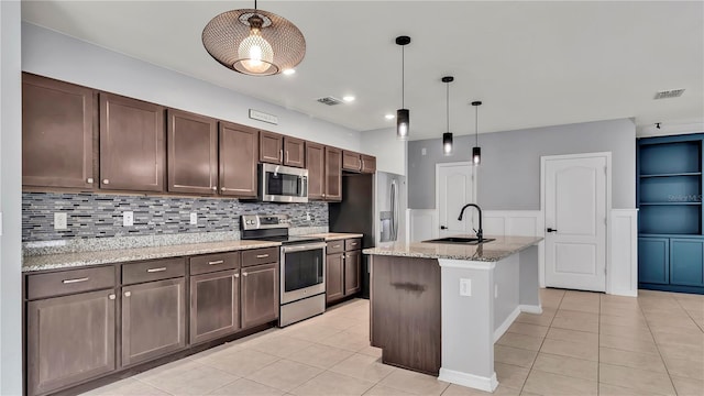 kitchen with visible vents, a sink, appliances with stainless steel finishes, light tile patterned flooring, and dark brown cabinets