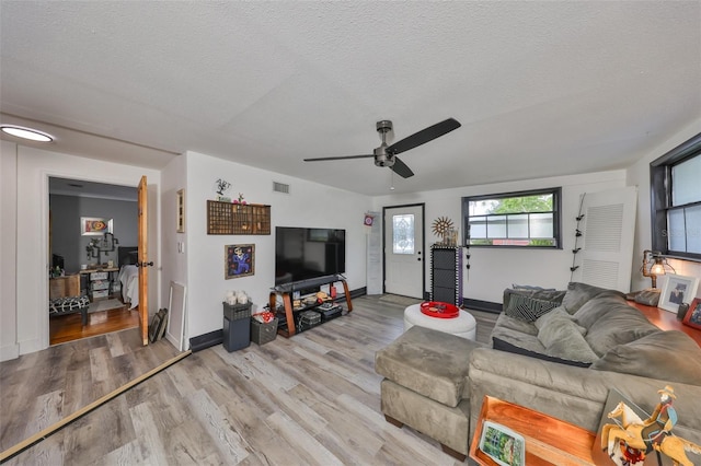 5601 2nd Ave N, Saint Petersburg, FL 33710 - living room with a textured ceiling, ceiling fan, visible vents, baseboards, and light wood finished floors