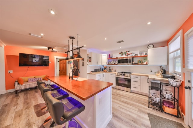 5601 2nd Ave N, Saint Petersburg, FL 33710 - kitchen featuring visible vents, light wood-style flooring, appliances with stainless steel finishes, open shelves, and a sink