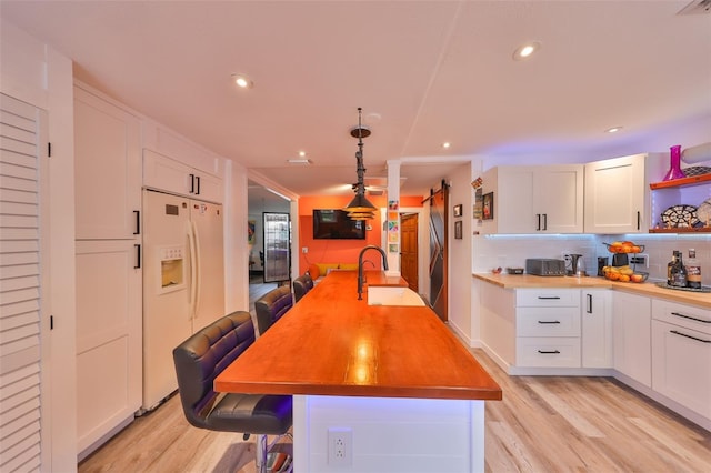 5601 2nd Ave N, Saint Petersburg, FL 33710 - kitchen with white refrigerator with ice dispenser, white cabinetry, a sink, and open shelves