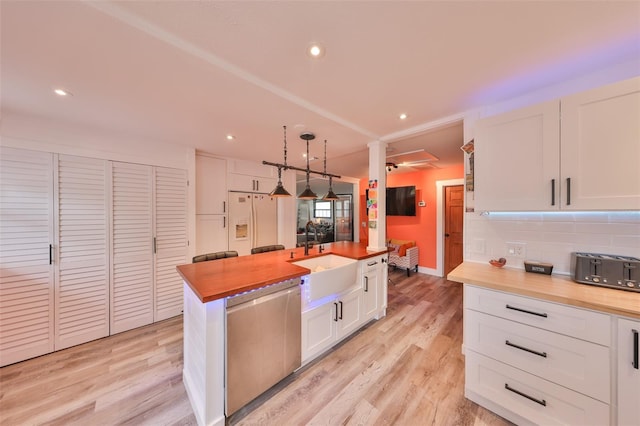 5601 2nd Ave N, Saint Petersburg, FL 33710 - kitchen featuring white refrigerator with ice dispenser, dishwasher, butcher block counters, white cabinetry, and a sink