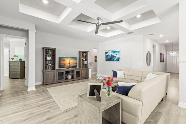 living room with ceiling fan with notable chandelier, coffered ceiling, baseboards, and light wood-style floors