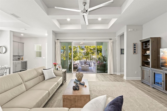 living area featuring recessed lighting, visible vents, light wood-style flooring, beverage cooler, and baseboards