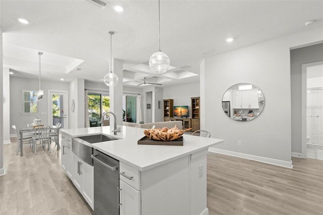 kitchen featuring light wood finished floors, white cabinetry, stainless steel appliances, and a sink