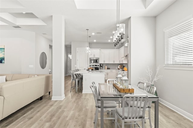 dining room featuring light wood-type flooring, baseboards, and recessed lighting