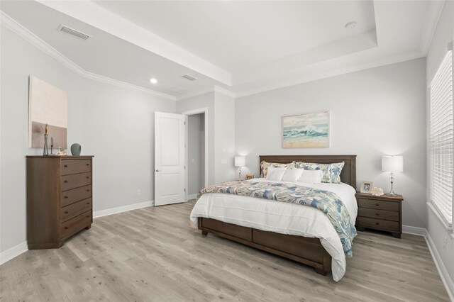 bedroom with baseboards, visible vents, crown molding, and light wood finished floors