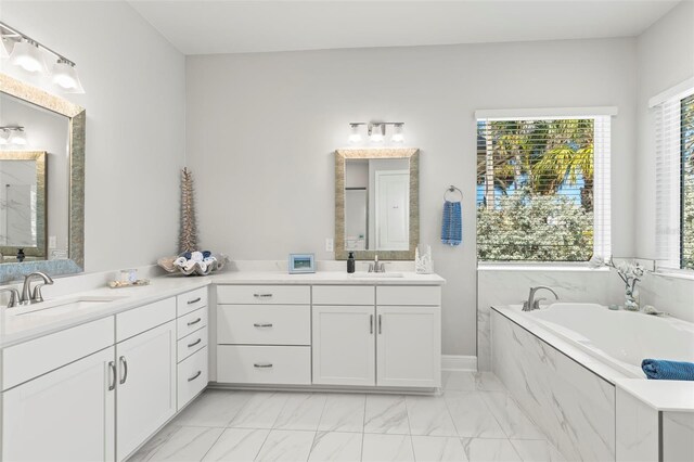 full bathroom with marble finish floor, vanity, and a bath