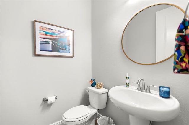 bathroom with toilet, baseboards, and a sink