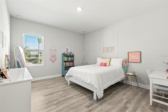 bedroom featuring light wood-style flooring and baseboards