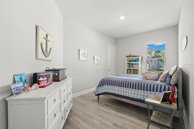 bedroom with light wood-style flooring and baseboards