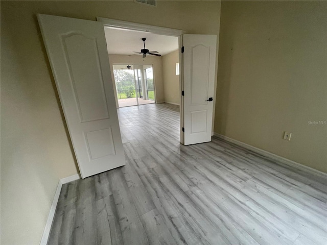 spare room with visible vents, baseboards, and wood finished floors