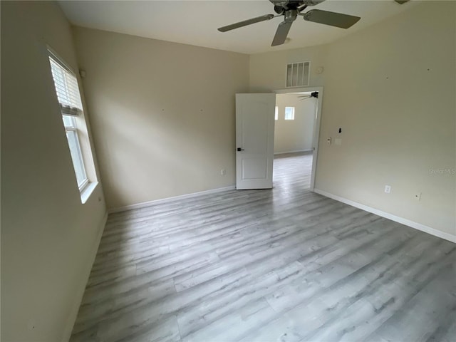 empty room featuring visible vents, baseboards, and wood finished floors