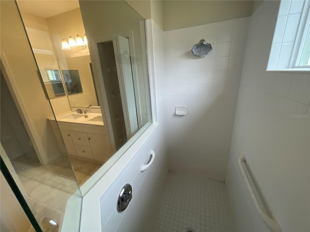 bathroom featuring a tile shower, vanity, and tile patterned floors