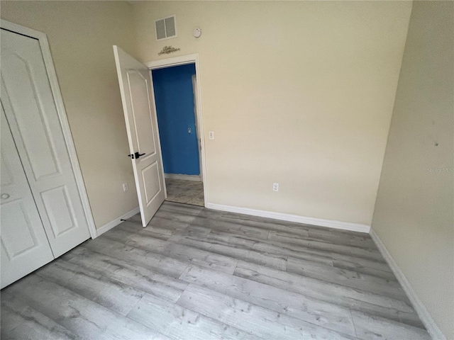 interior space with baseboards, visible vents, and wood finished floors