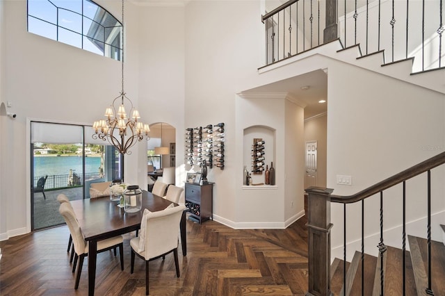 dining space with a chandelier, stairway, crown molding, and baseboards