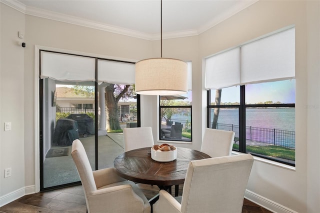 dining space featuring baseboards, wood finished floors, and crown molding