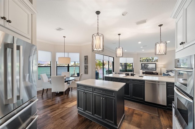 kitchen with light countertops, appliances with stainless steel finishes, visible vents, and dark cabinets