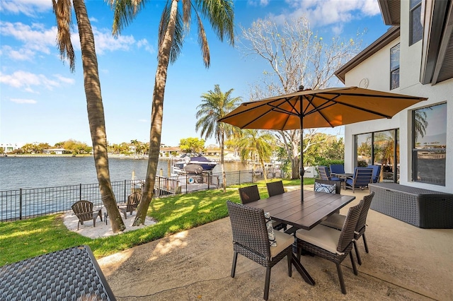 view of patio / terrace with outdoor dining area, a water view, and fence