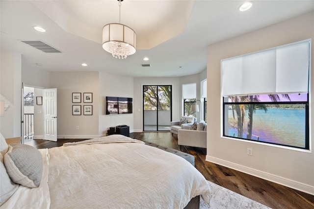 bedroom featuring baseboards, visible vents, dark wood-style flooring, a tray ceiling, and recessed lighting