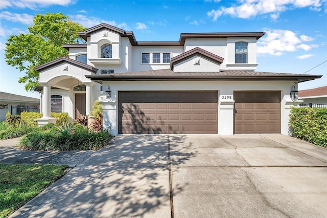 view of front of house featuring driveway, an attached garage, and stucco siding