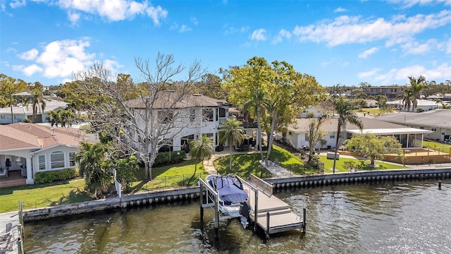 view of dock with a lawn, a water view, and a residential view