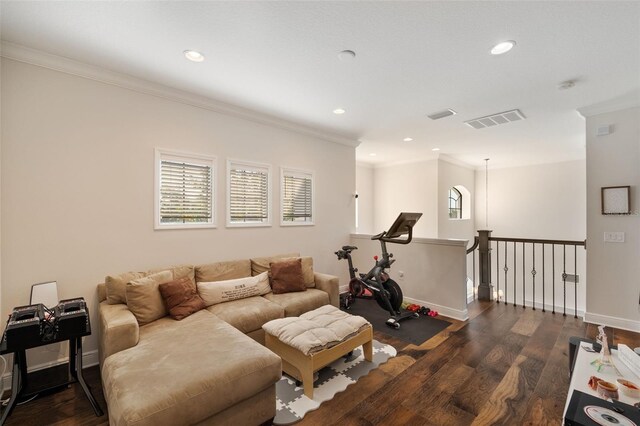 living room featuring a wealth of natural light, dark wood-type flooring, visible vents, and crown molding