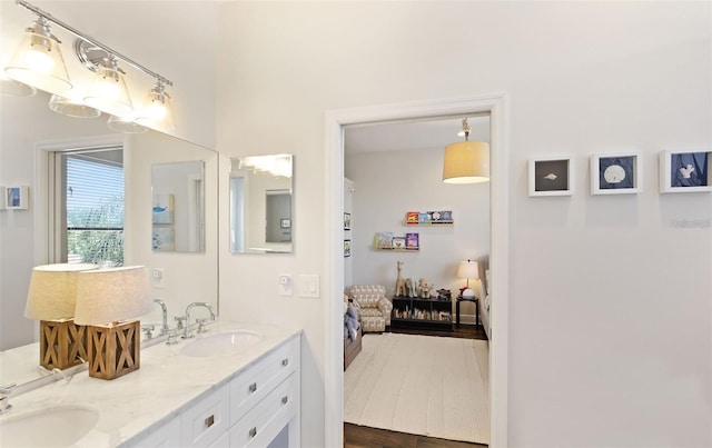 ensuite bathroom featuring a sink, ensuite bath, and double vanity