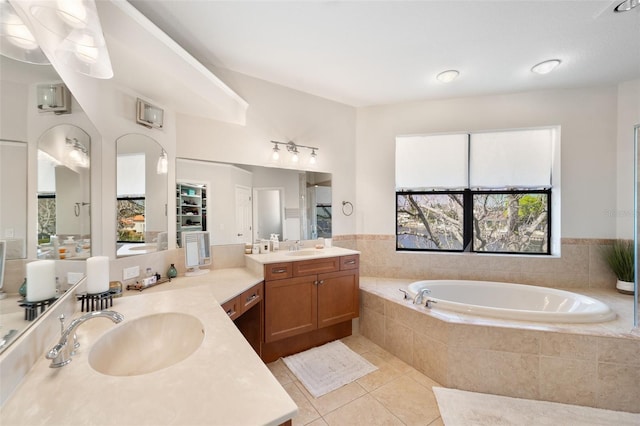 bathroom featuring two vanities, a sink, a bath, and tile patterned floors