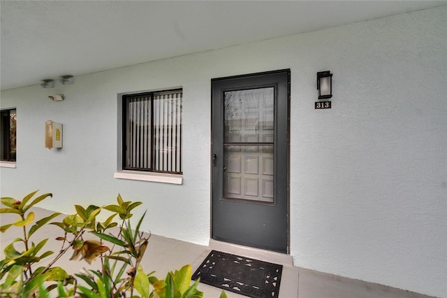 entrance to property featuring stucco siding