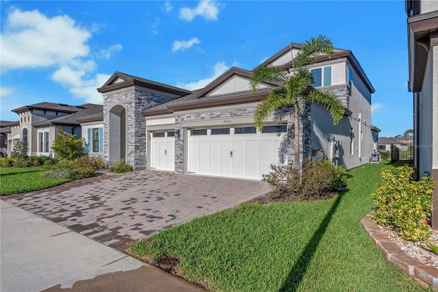 view of front facade with stone siding, a front lawn, decorative driveway, and an attached garage