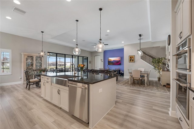 kitchen with stainless steel appliances, light wood-type flooring, visible vents, and a sink