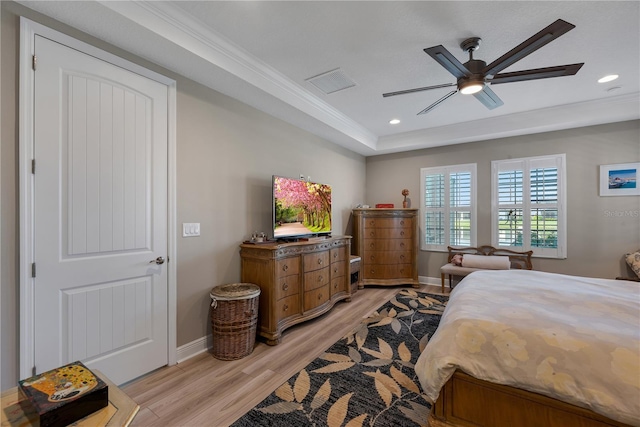 bedroom featuring a tray ceiling, light wood finished floors, recessed lighting, and baseboards