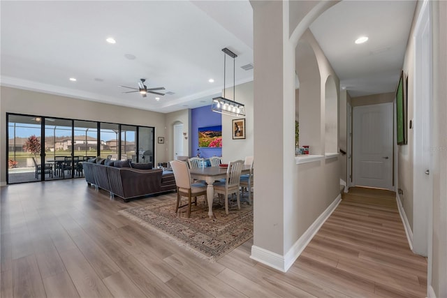 interior space with light wood-type flooring, baseboards, arched walkways, and recessed lighting