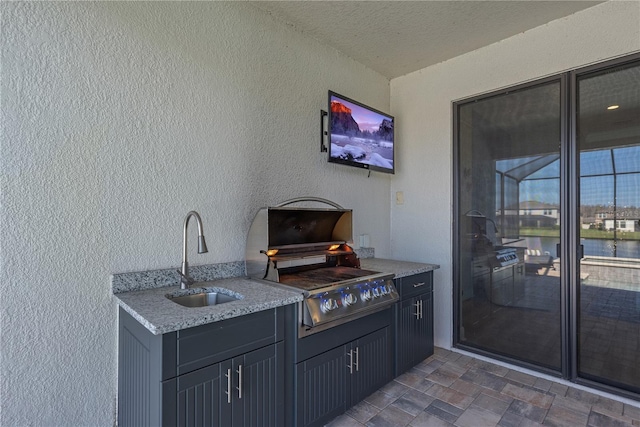 view of patio / terrace with a sink, grilling area, and an outdoor kitchen