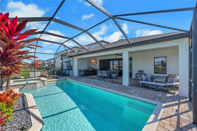 view of pool with a patio, a pool with connected hot tub, an outdoor hangout area, ceiling fan, and a lanai