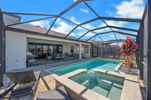 view of swimming pool featuring ceiling fan, a patio area, a lanai, and a pool with connected hot tub