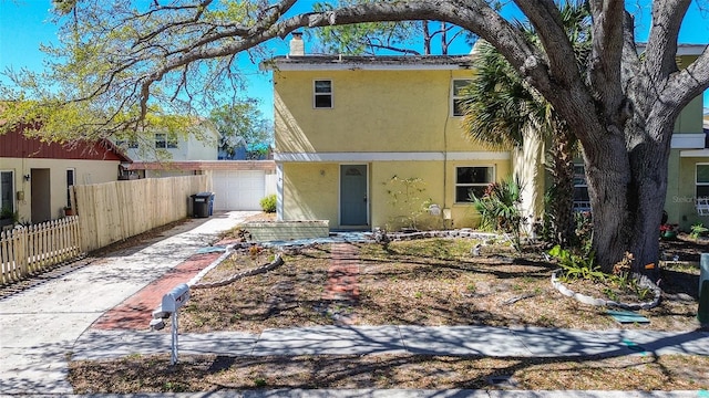 view of front of house with a garage, fence, concrete driveway, stucco siding, and a chimney