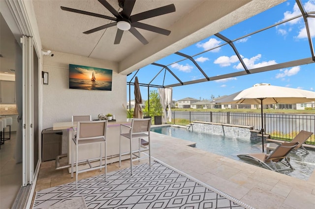 view of pool with outdoor dry bar, a patio area, ceiling fan, fence, and a lanai