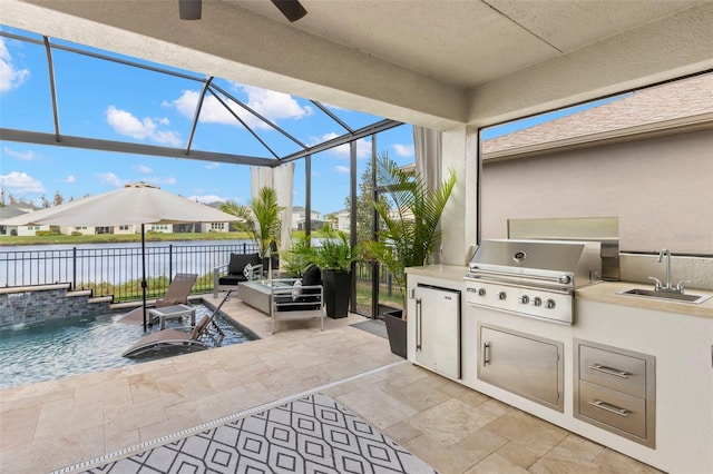 view of patio / terrace with a water view, an outdoor kitchen, area for grilling, a sink, and a lanai